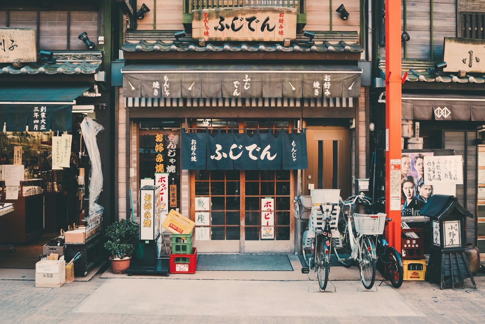 A small neighbourhood shopfront with a noren curtain and parked bicycles